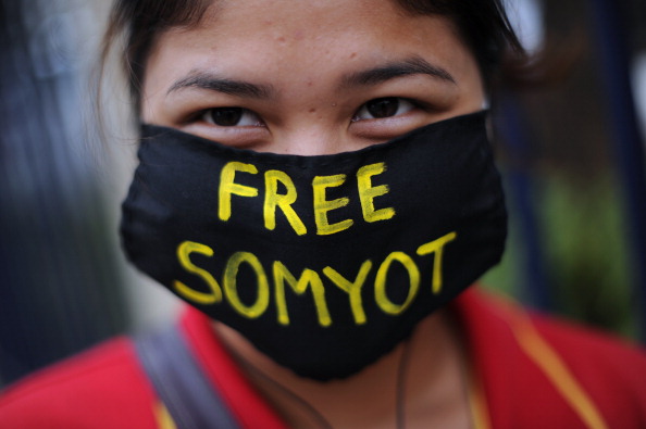 A Thai activist wears a face mask carrying a message reading 'Free Somyot' as she joins a protest outside the Criminal Court in Bangkok on January 25, 2013.      (Photo credit:  CHRISTOPHE ARCHAMBAULT/AFP/Getty Images)