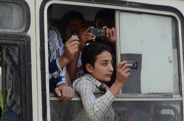 Syrian youths, inside a vehicle, film a protest against the regime of Syrian President Bashar al-Assad with their phones in the northern city of Aleppo.