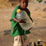 A Malian girl carries a water can she just partially filled at a water pump in northern Mali's city of Gao (Photo credit should read Pascal Guyot/AFP/Getty Images).