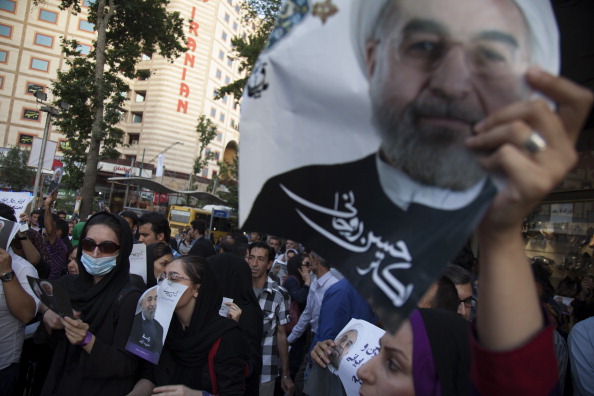 People hold campaign posters of Iranian presidential candidate, Hassan Rowhani in the streets during a presidential election rally on June 11, 2013 in Tehran, Iran (Photo Credit: Majid Saeedi/Getty Images).