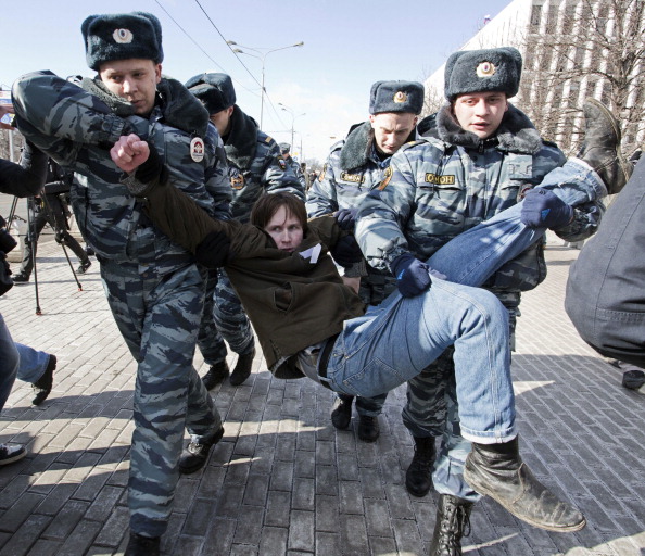 Policemen detain an opposition supporter taking part in a picketing calling for the release of the two jailed members the Pussy Riot (Photo Credit: Evgeny Feldman/AFP/Getty Images).