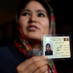 An Afghan woman displays her voter registration card at a voter registration center (Photo Credit: Shah Marai/AFP/Getty Images).