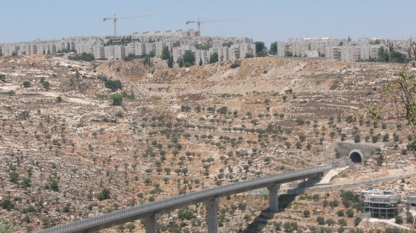 An 'Israeli only' by-pass road that links Israeli settlements in the occupied West Bank, sitting below an Israeli settlement outside of Jerusalem (Photo Credit:  Edith Garwood).