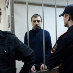 Mikhail Kosenko, one of the activists accused of violence at a rally on the eve of President Vladimir Putin's inauguration, stands in a defendant cage in a court in Moscow, on October 8, 2013. A court in Moscow was scheduled to render today its verdict in the case of Mikhail Kosenko, of the so-called Bolotnaya case against demonstrators charged with instigating 'mass disturbances' on the eve of Putin's inauguration. AFP PHOTO / VASILY MAXIMOV (Photo credit should read VASILY MAXIMOV/AFP/Getty Images)
