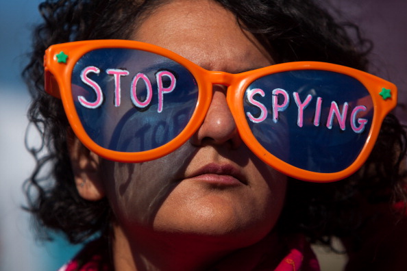 A woman listens to speakers during the Stop Watching Us Rally protesting surveillance by the U.S. National Security Agency (Photo Credit: Allison Shelley/Getty Images).