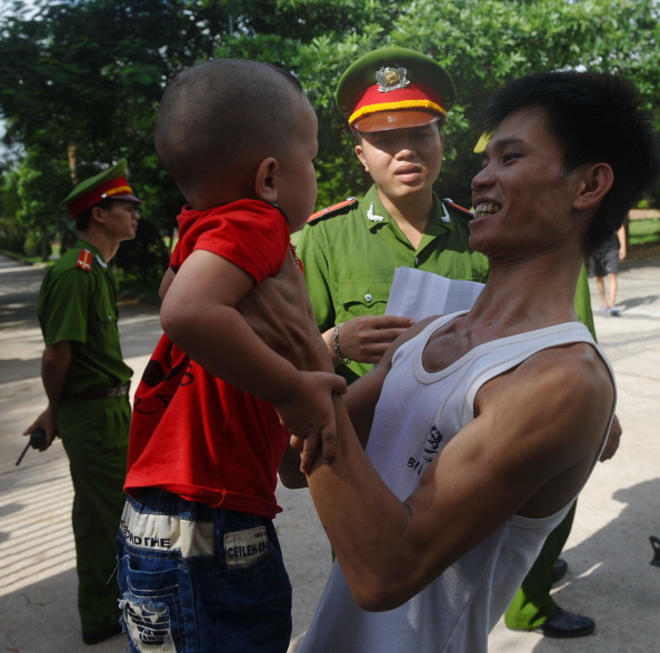 A released prisoner holds his son at the main entrance of the Hoang Tien prison in Viet Nam (Photo Credit: Hoang Dinh Nam/AFP/Getty Images).