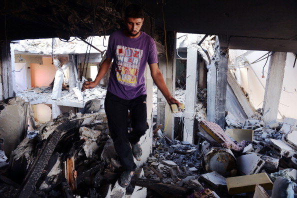 Ziad Assam walks on rubble inside an apartment complex where he used to live on August 13, 2014. It was heavily damaged in fighting between Israel and Hamas during four weeks of fighting in northern Gaza strip. (Photo credit: Roberto Schmidt/AFP/Getty Images)