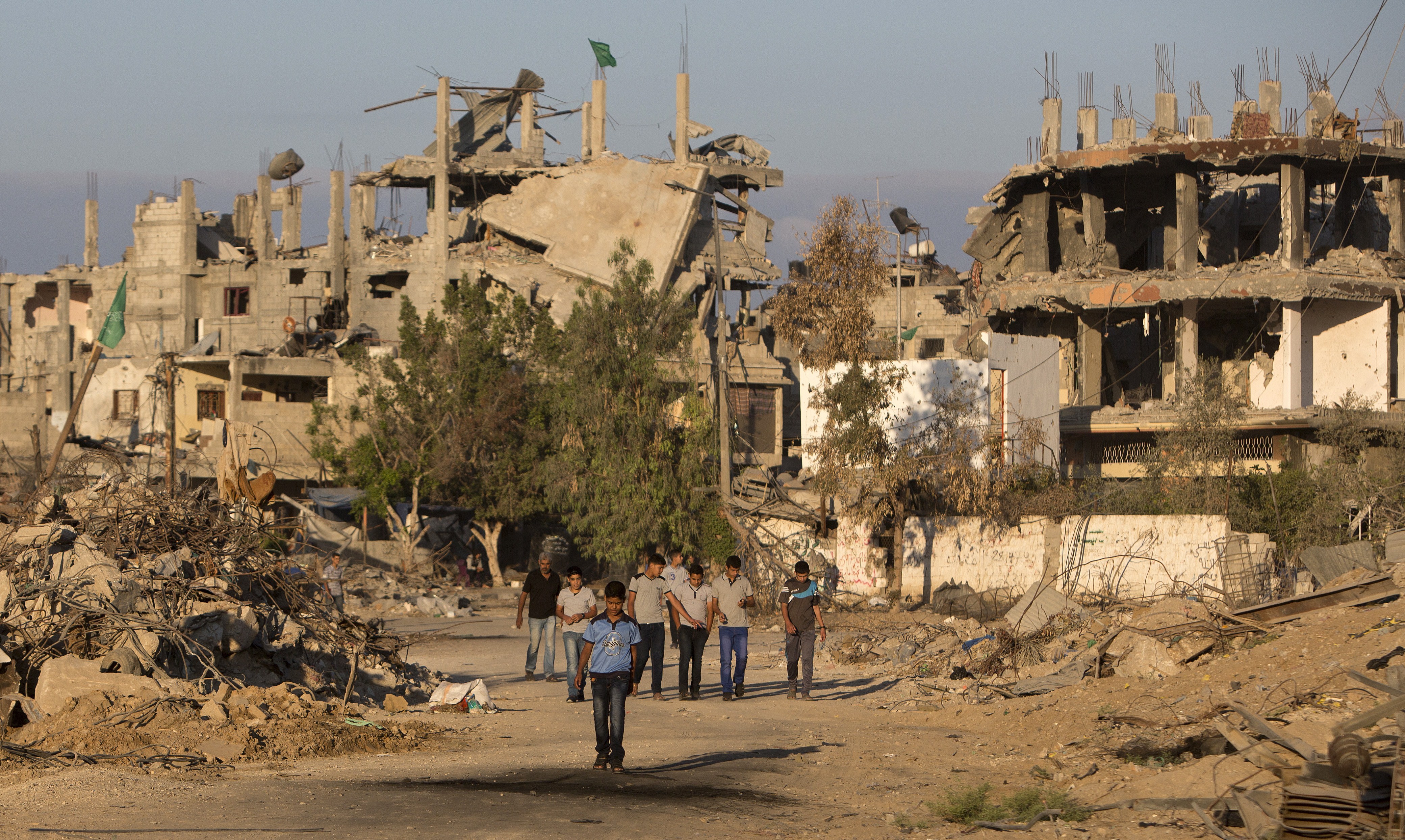 Palestinian boys walk past buildings which were destroyed by Israeli strikes on their way to school in the Shejaiya neighbourhood of Gaza City on September 14, 2014 on the first day of the new school year. (MAHMUD HAMS/AFP/Getty Images)