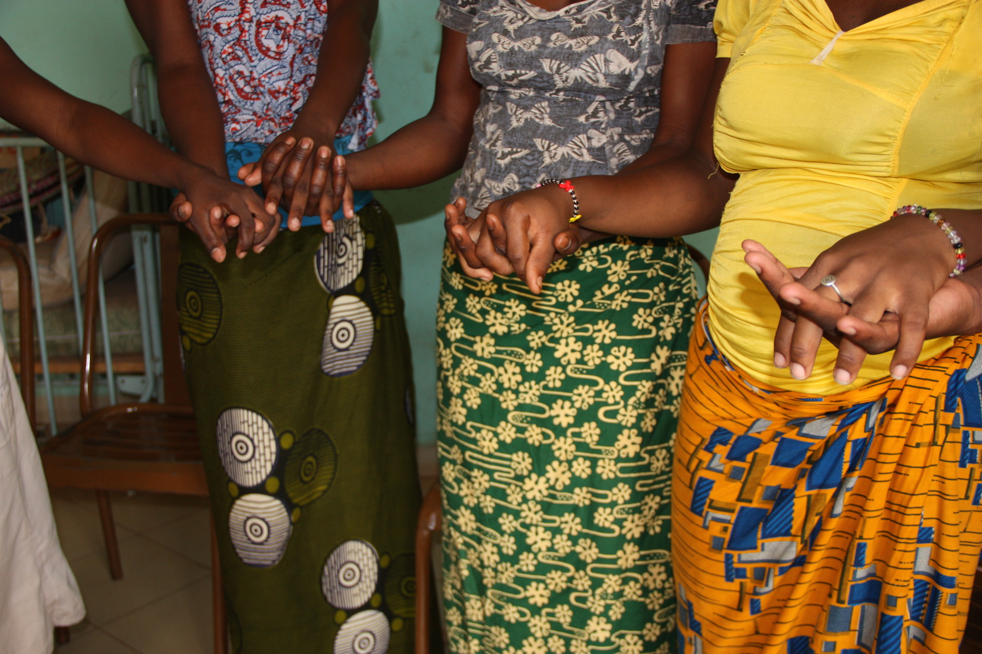 Young women hold hands in a shelter run by Nuns, these young women have courageously fled forced marriage or early and unwanted pregnancies. Ouagadougou. July 2014