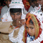 Indian groom puts vermilion on the forehead of his underage bride during a mass marriage in Malda, India 02 March 2006. (STRDEL/AFP/Getty Images)
