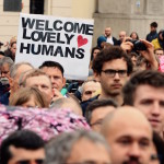 Participans of a pro-migrant demonstration hold placards written 'Welcome lovely humans' in Warsaw on September 12, 2015, as a counter-demonstration against a right-wing gathering against migrants at the same time. The counter-demonstration drew around 1,000 people welcoming migrants into Poland, an EU member of 38 million people which has seen virtually no refugees arriving during the current crisis.  AFP PHOTO / JANEK SKARZYNSKI