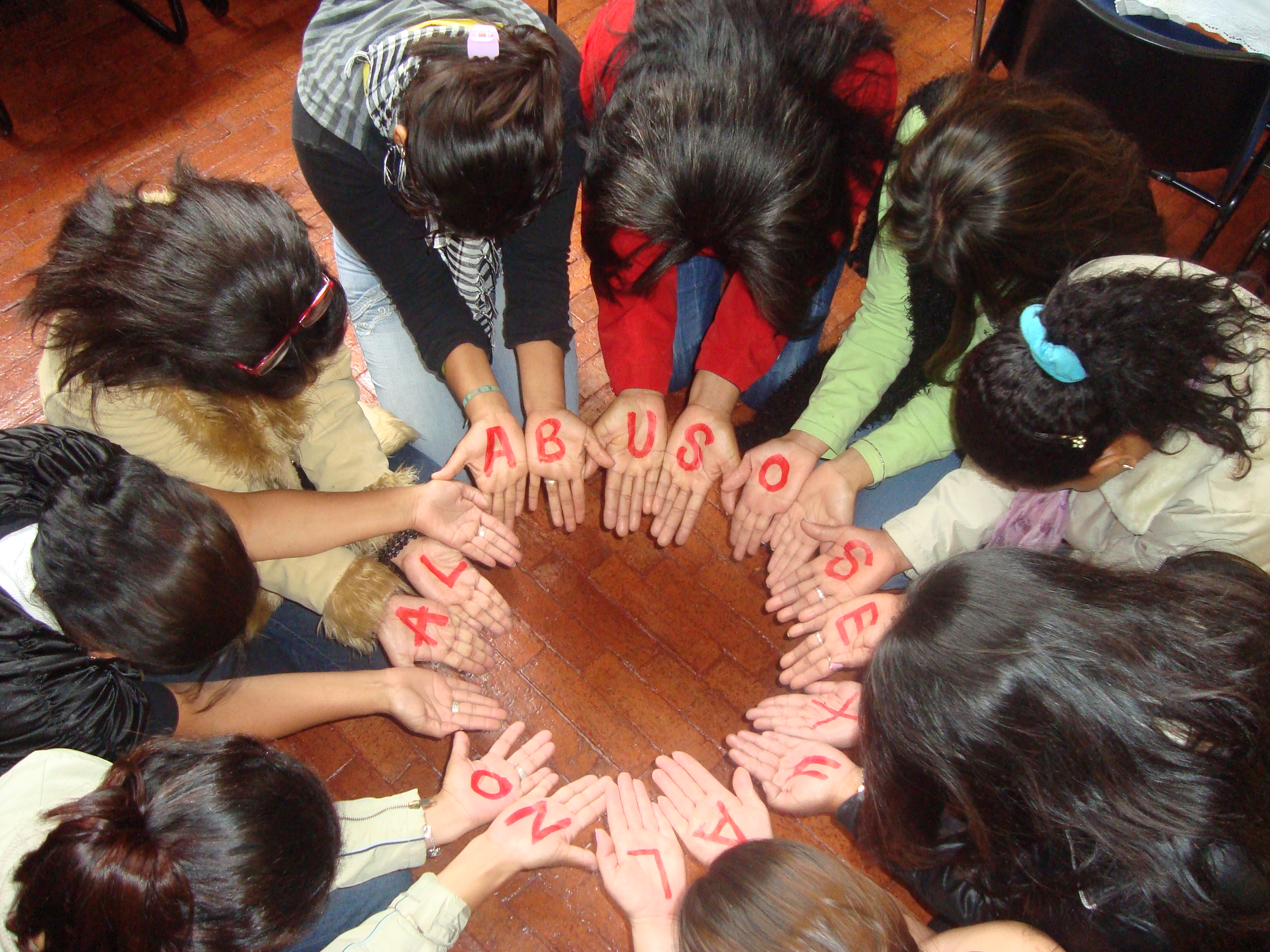 Members of a support group for survivors of sexual violence create a circle with their hands, Bogotá, Colombia, March 2011. The letters on the hands of the women in a circle form the words "No al abuso sexual" (No to sexual abuse). They are a group of women who have been victims of sexual violence in the armed conflict in Colombia who meet regularly.