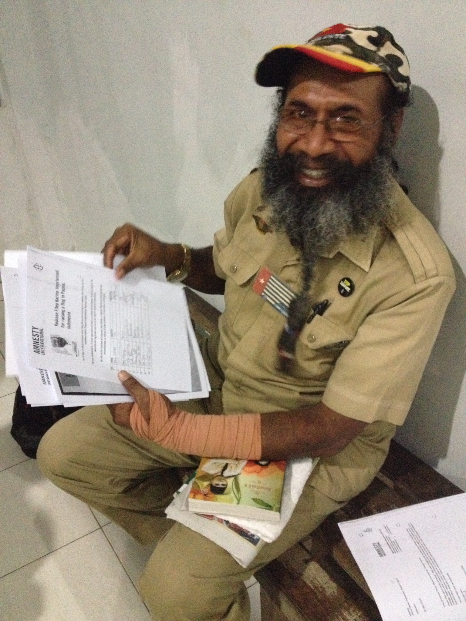 Filep Karma with petitions signed by Amnesty International activists calling for his release. He is smiling. Filep Karma is serving 15 years in prison for raising a flag. A prominent advocate for the rights of Indonesia's Papuan population, Filep Karma was arrested for taking part in a peaceful ceremony on December 1, 2004, which included the raising of the Morning Star flag, a Papuan symbol. Amnesty International considers Filep Karma to be a prisoner of conscience who has been imprisoned solely for the peaceful and legitimate exercise of his right to freedom of expression.