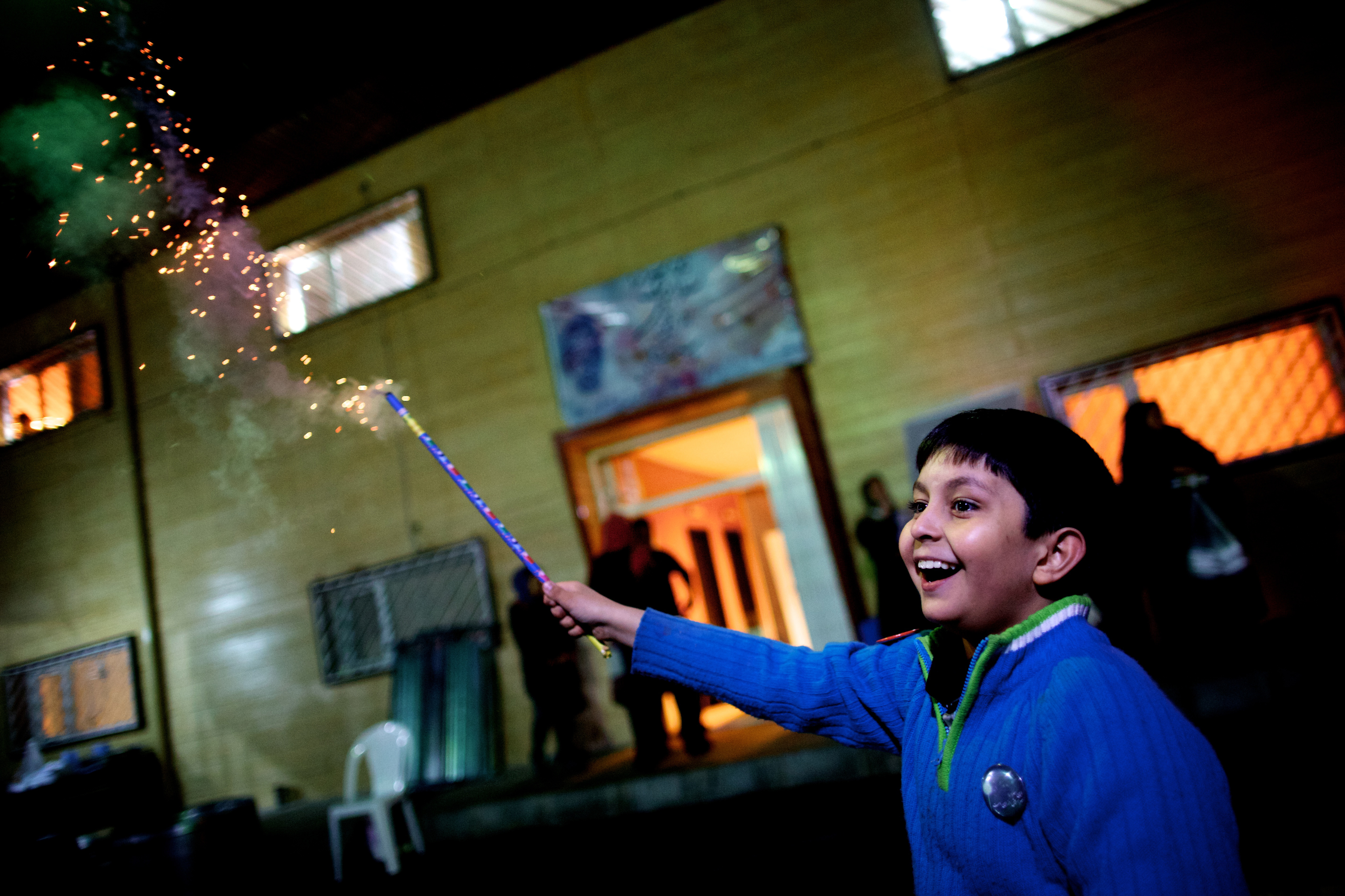 An Iranian boy holds a fire cracker in southern Tehran on March 19, 2013 during the Wednesday Fire feast, or Chaharshanbeh Soori, held annually on the last Wednesday eve before the Spring holiday of Noruz. The Iranian new year that begins on March 20 coincides with the first day of spring during which locals revive the Zoroastrian celebration of lighting a fire and dancing around the flame. AFP PHOTO/BEHROUZ MEHRI        (Photo credit should read BEHROUZ MEHRI/AFP/Getty Images)
